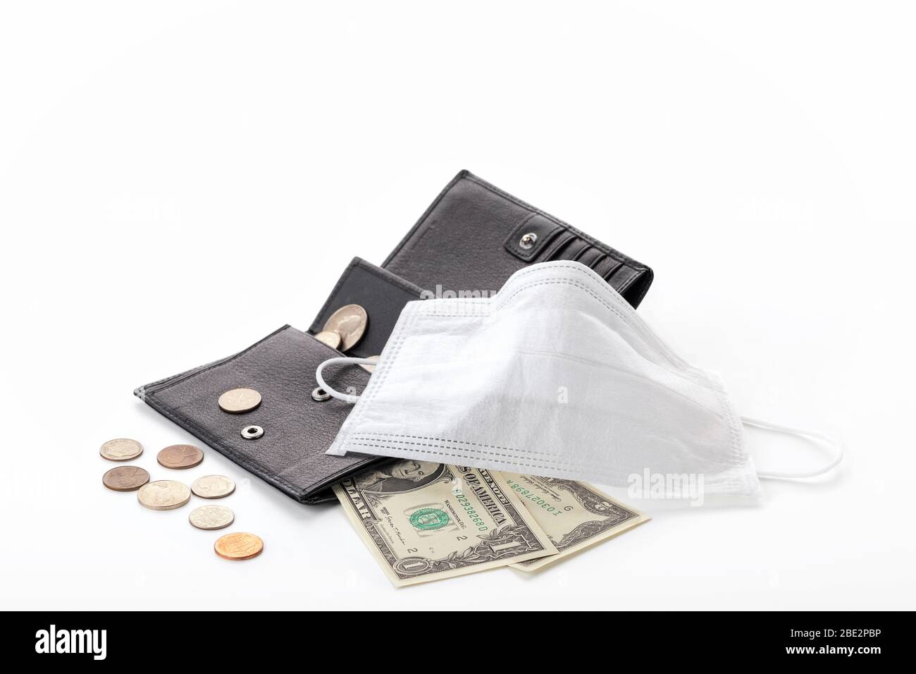 Concept of a global crisis and falling incomes  due to pandemic coronavirus COVID-19. Wallet with one dollar, cents and a protective mask isolated on Stock Photo