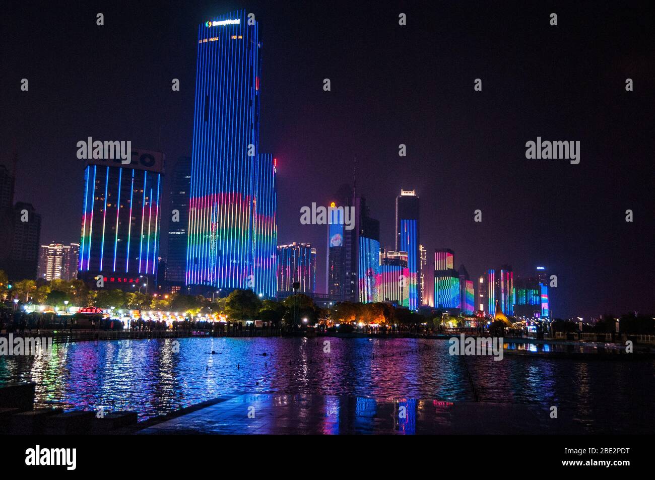 Office buildings lit up on the waterfront of the Gan River, Nanchang, Jiangxi Province, China Stock Photo