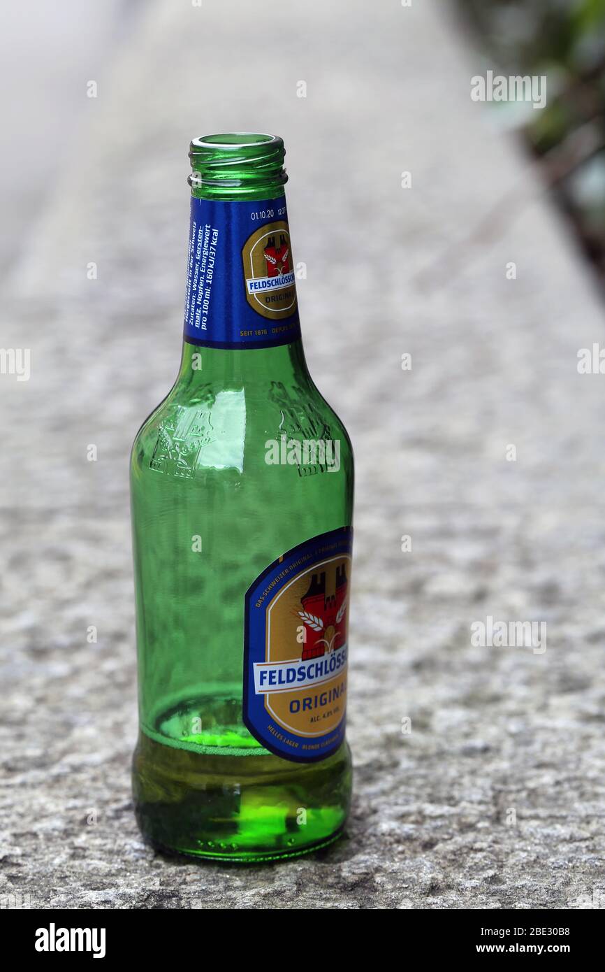 https://c8.alamy.com/comp/2BE30B8/green-feldschlsschen-beer-bottle-made-of-glass-the-bottle-is-almost-empty-and-abandoned-to-the-streets-of-zrich-switzerland-march-2020-closeup-2BE30B8.jpg