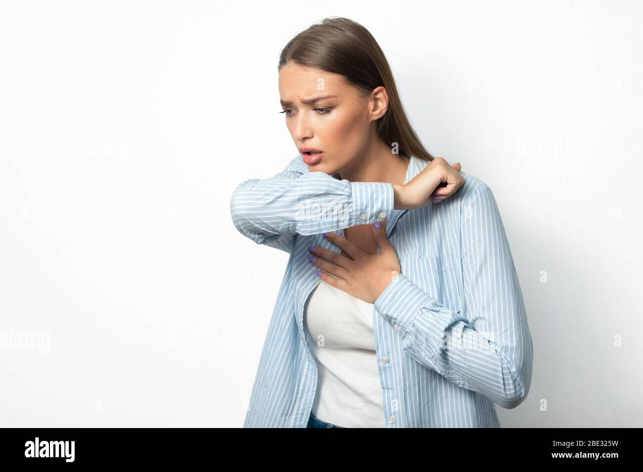 Girl Coughing Into Elbow Having Difficulty Breathing Over White