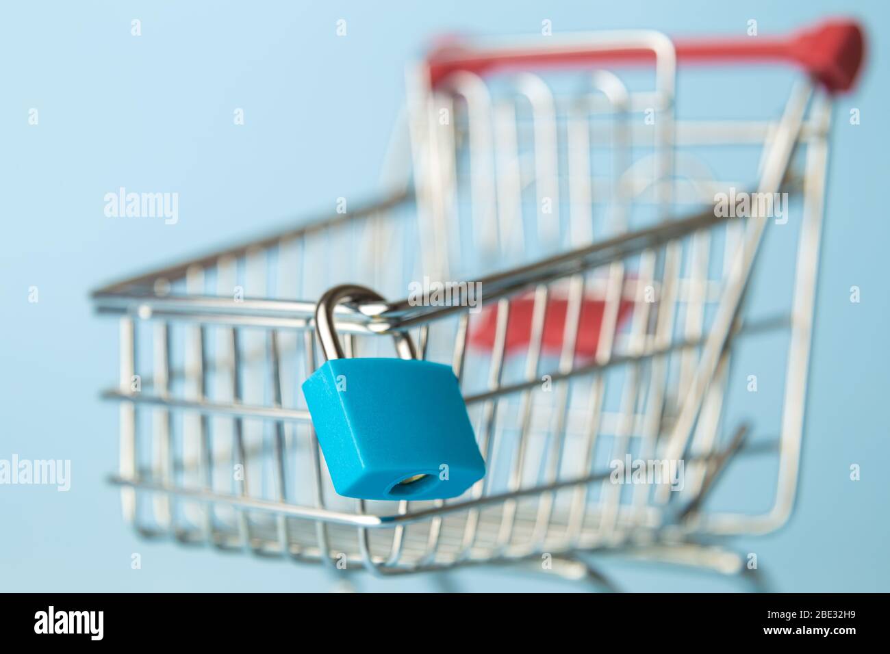 Close up of padlock on shopping cart minimal creative supermarket closed concept. Stock Photo