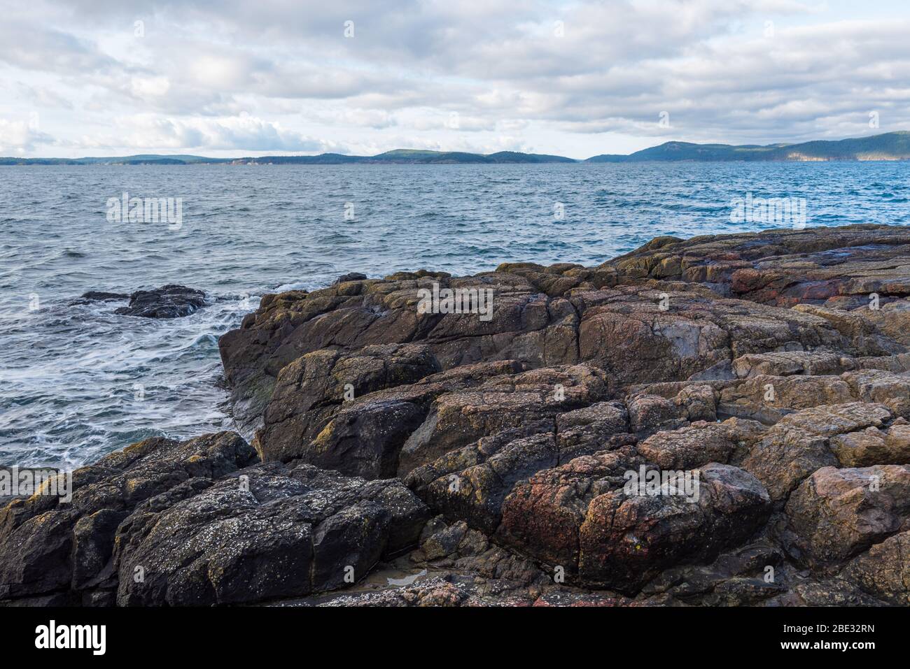 Landscape of horizontal rock formations and the Pacific Ocean at Washington Park in Anacortes, Washington Stock Photo