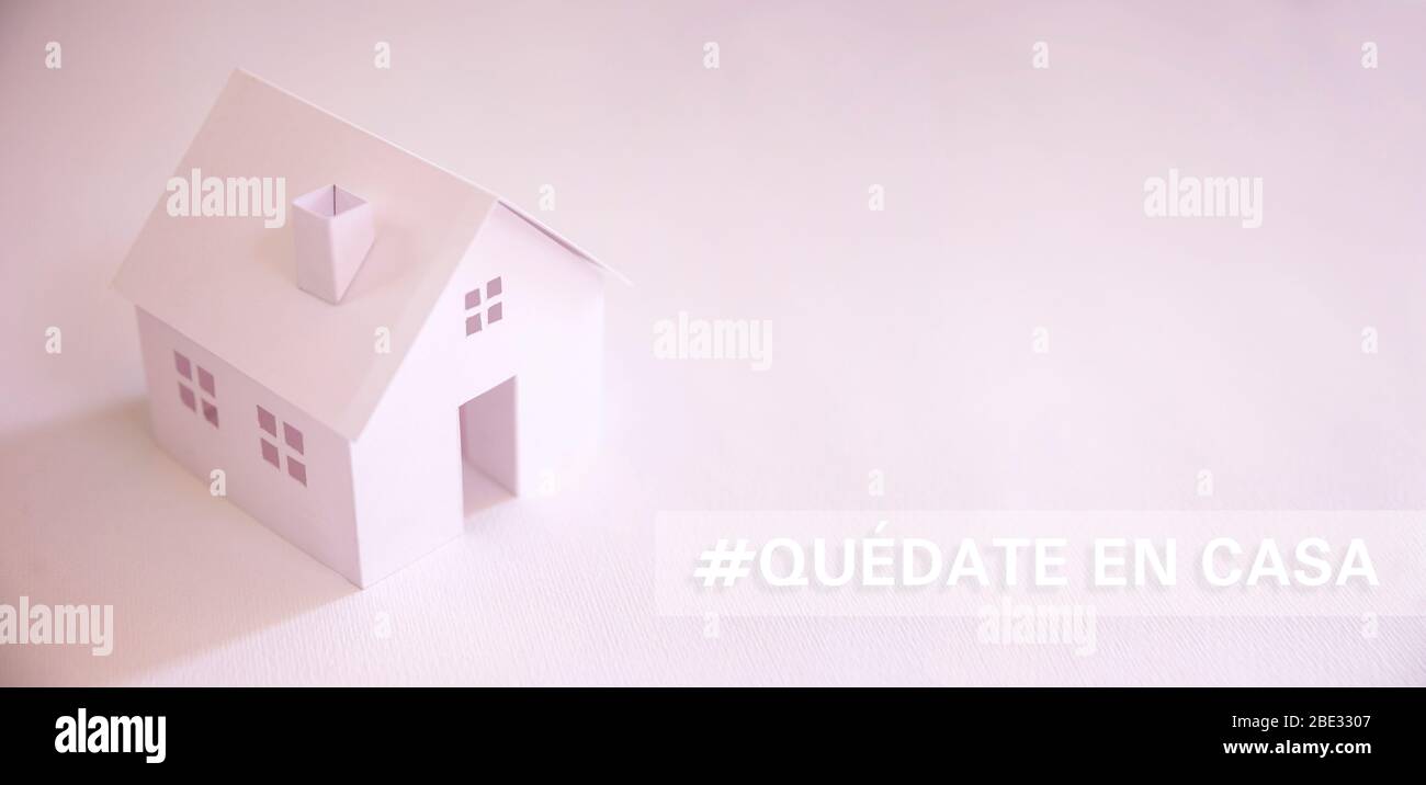 white paper house with text in spanish 'quedate en casa' (stay at home)  with copy space. Social distancing campaign during pandemic Stock Photo