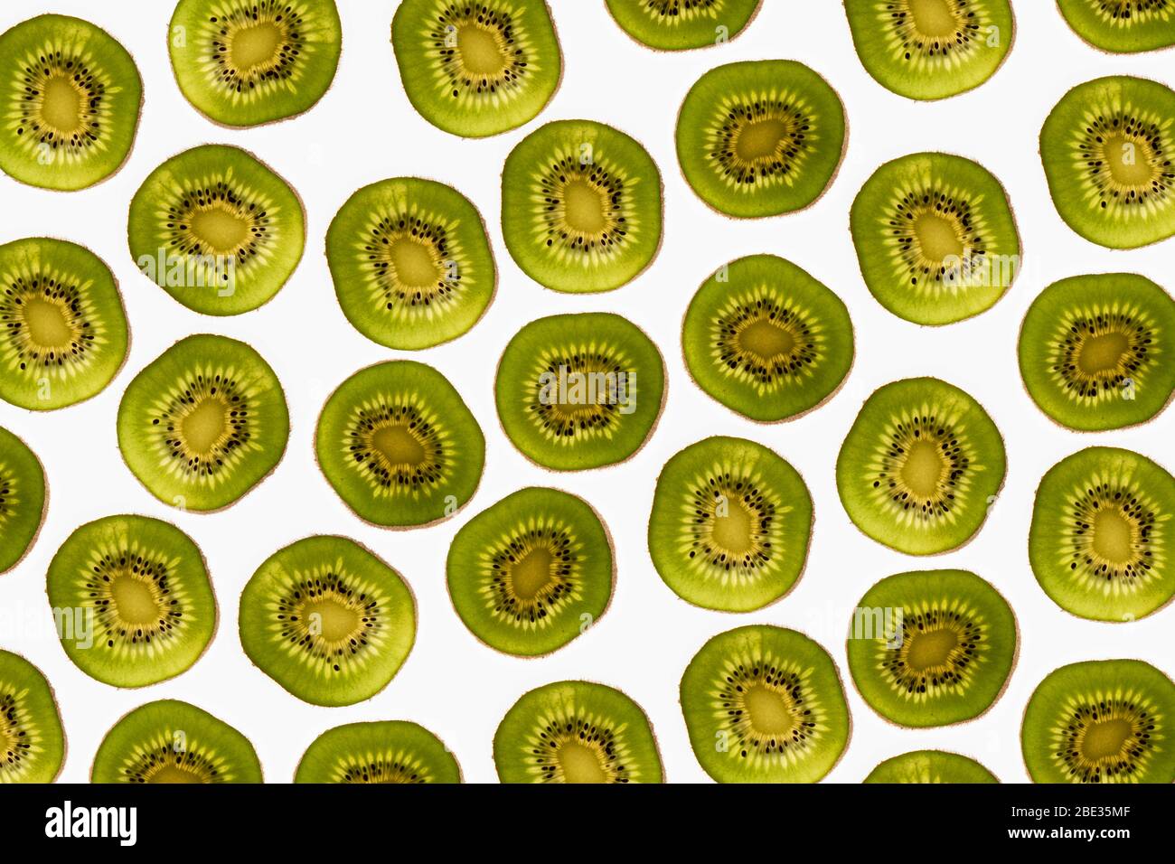 a beautiful image of an interesting pattern of kiwi fruit slices against a bright white background, flatlay Stock Photo