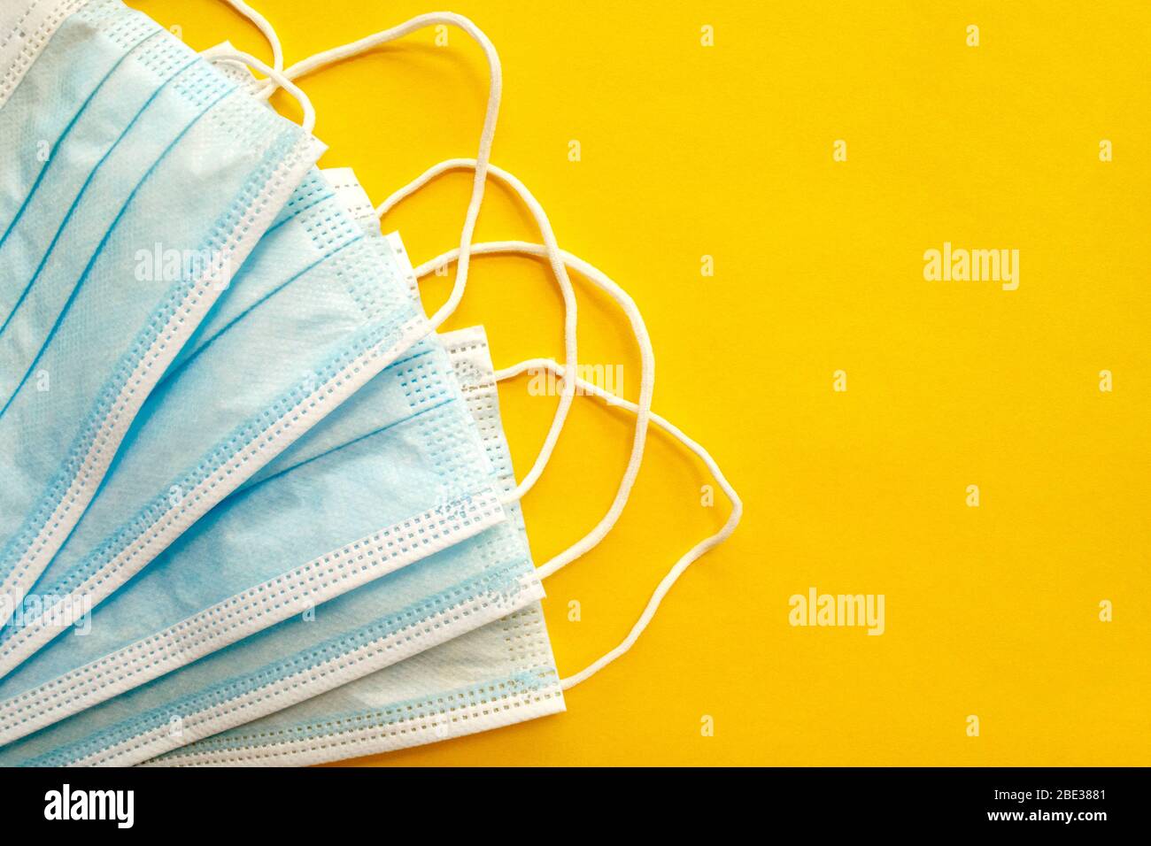 Surgical disposable face masks on yellow background. with copy space