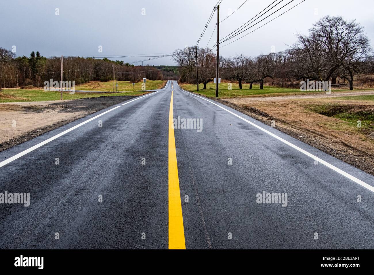 A road with a bright yellow center line Stock Photo