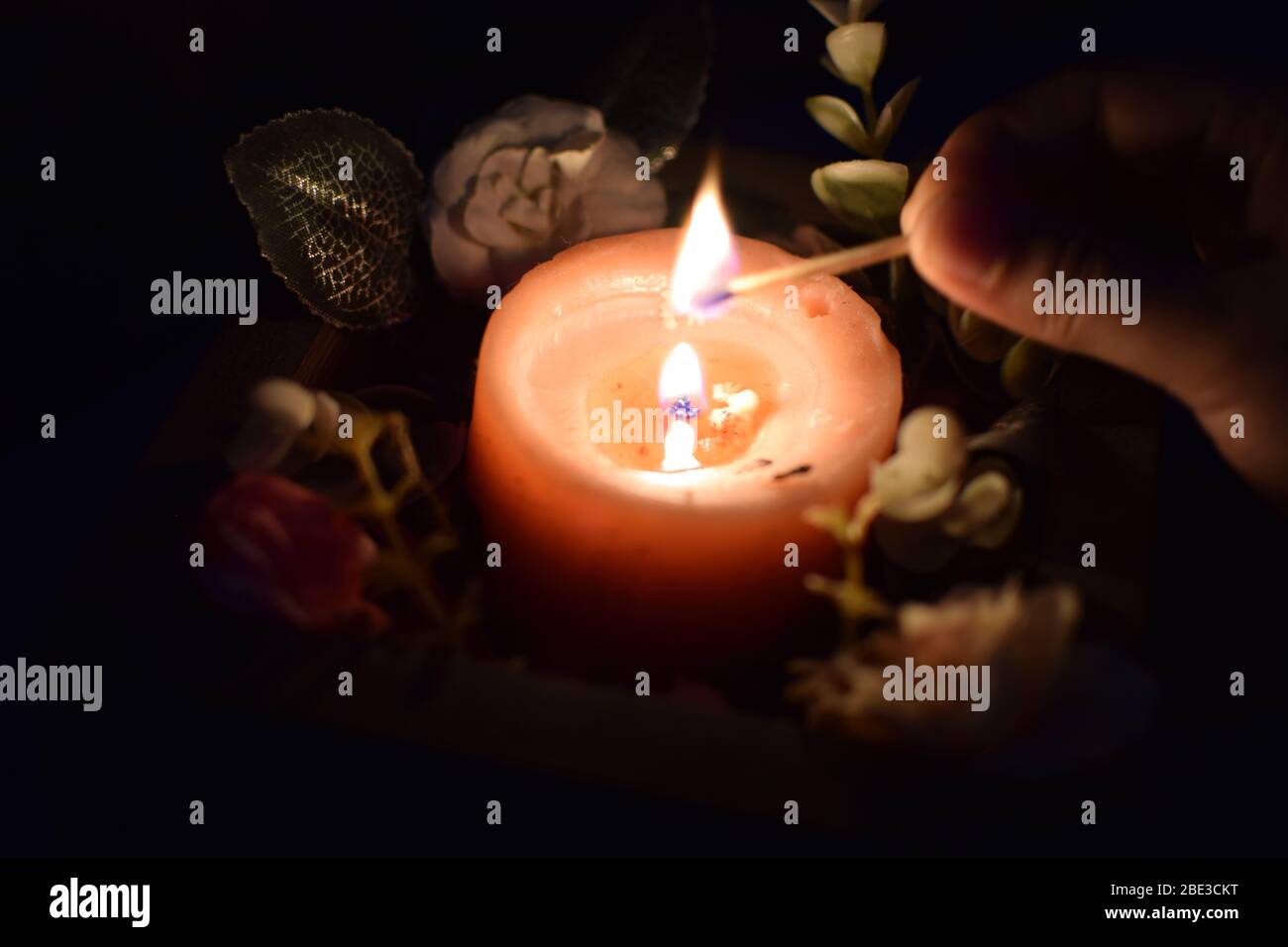 Close up view of pink candle with dark background at the back with