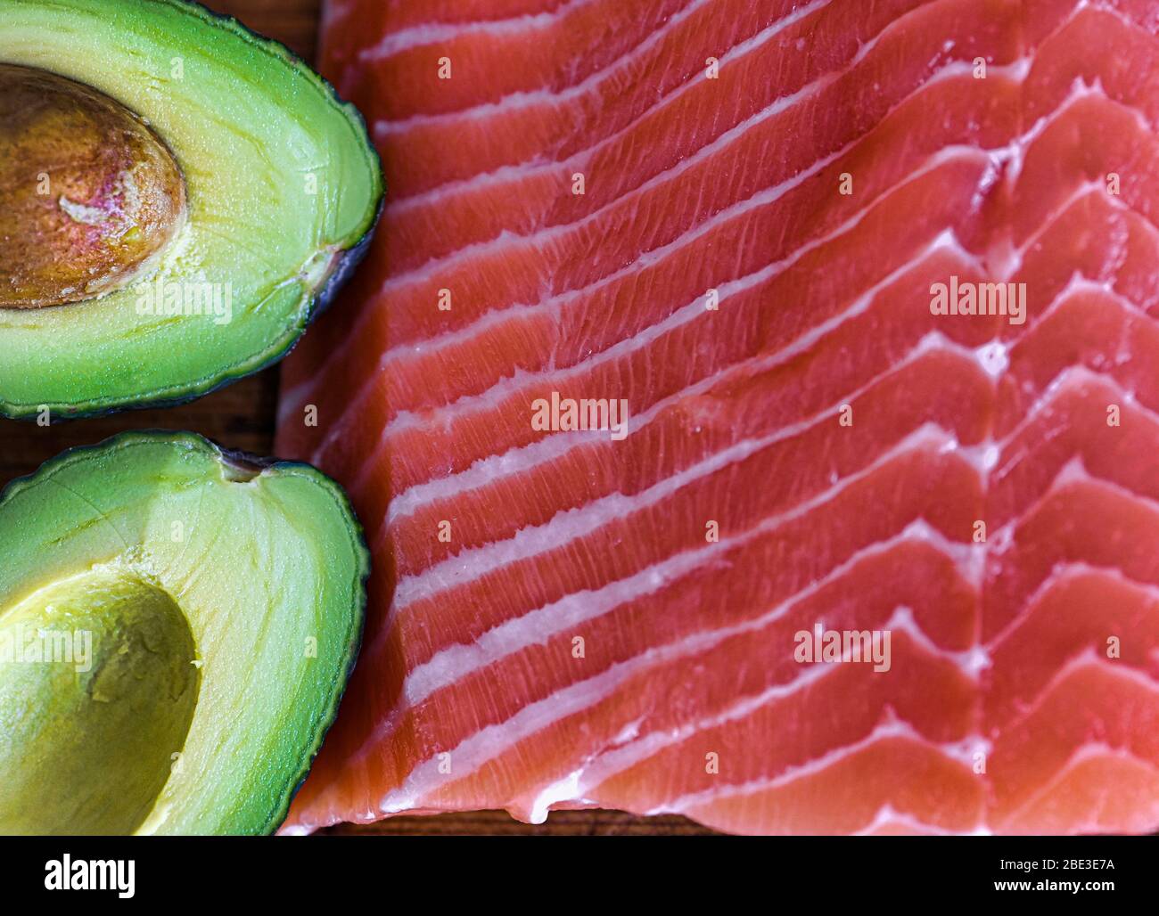 Close-up of raw salmon fillet and avocado cut in half Stock Photo