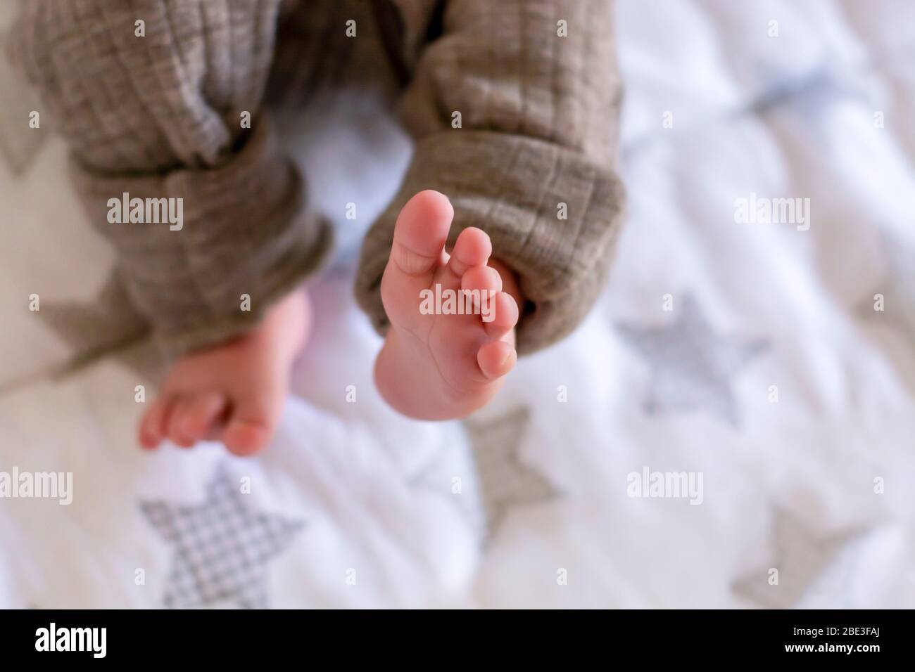 Newborn baby feet and tiny toes. View from above. Box sheet with star pattern Stock Photo