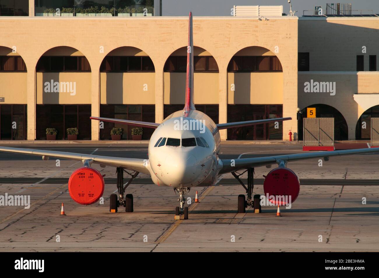Grounded Airbus A320 passenger jet plane idle at inactive airport. No proprietary details visible. Effect of COVID-19 coronavirus on air travel. Stock Photo