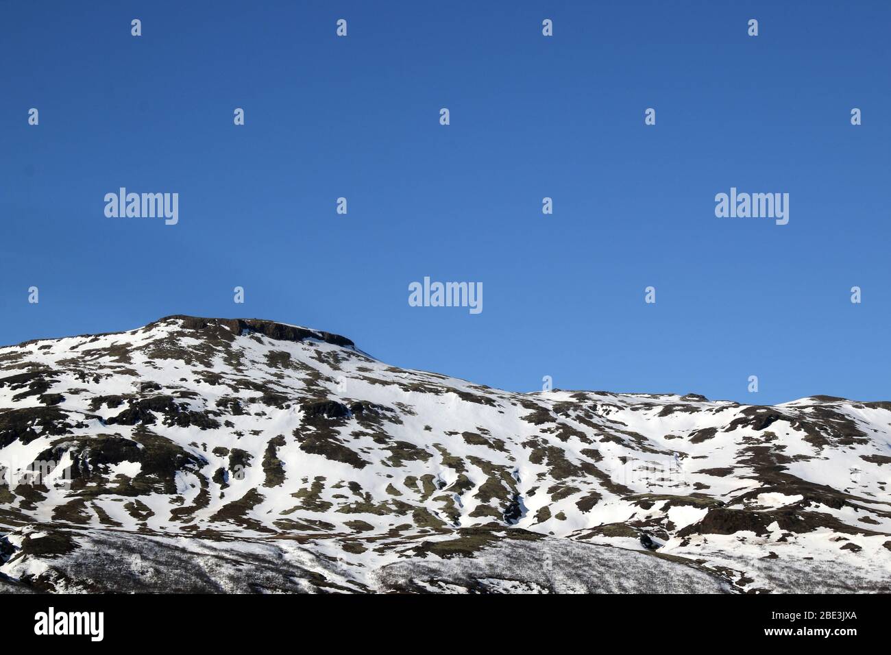 Snow capped mountains with blue skies Stock Photo - Alamy