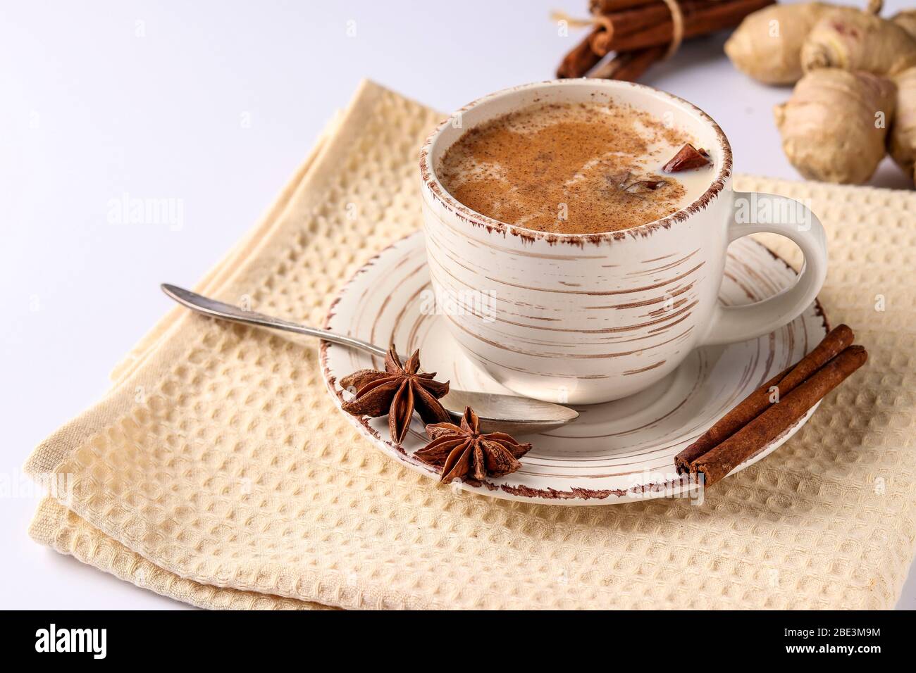 Traditional indian masala tea with spices in cup on a white background ...
