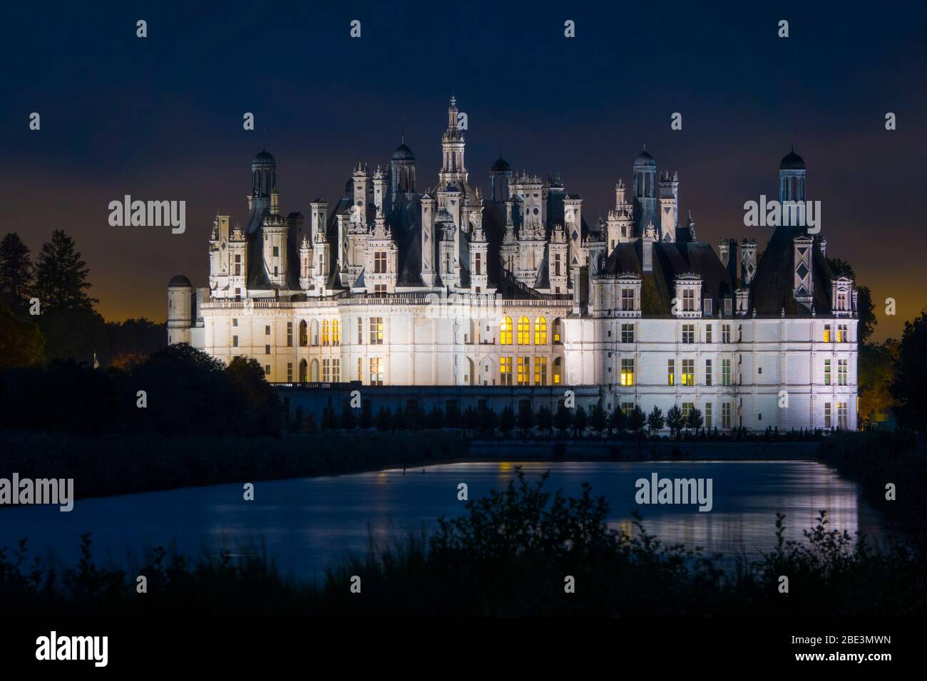 France, Loir-et-Cher (41), Chambord (Unesco World Heritage), royal castle from Renaissance period illuminated by night, viewed from the canal Le Cosso Stock Photo