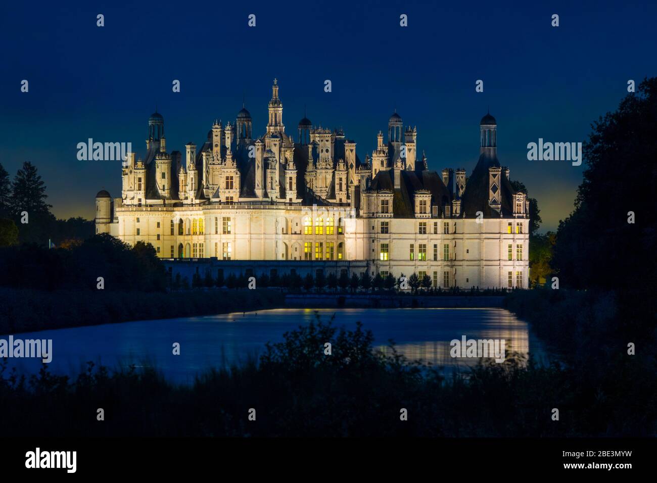 France, Loir-et-Cher (41), Chambord (Unesco World Heritage), royal castle from Renaissance period illuminated by night, viewed from the canal Le Cosso Stock Photo