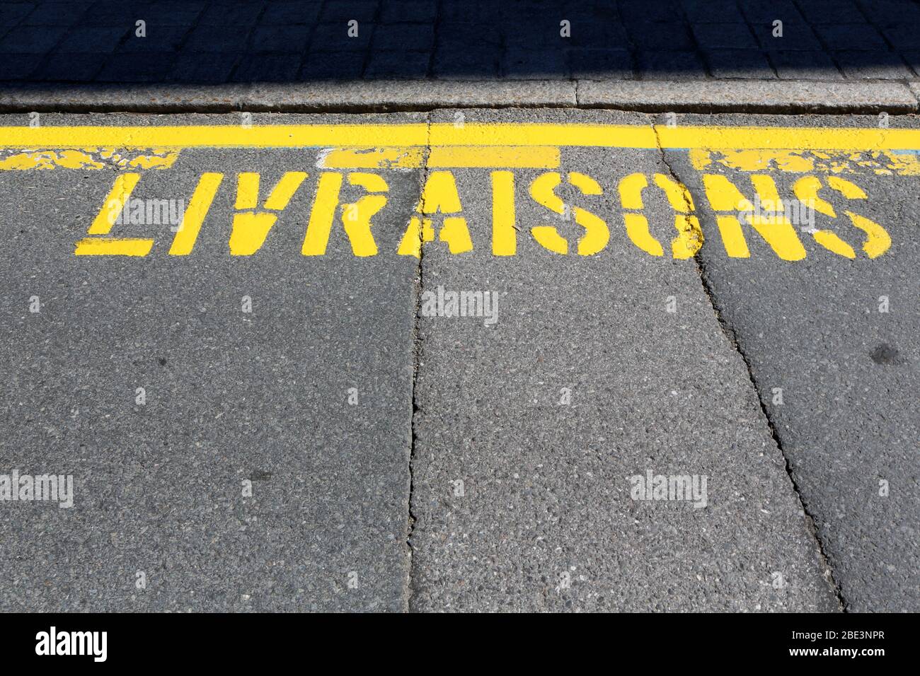 Livraisons. Inscription en peinture jaune sur une route. Saint-Gervais-les-Bains. Haute-Savoie. France. Stock Photo