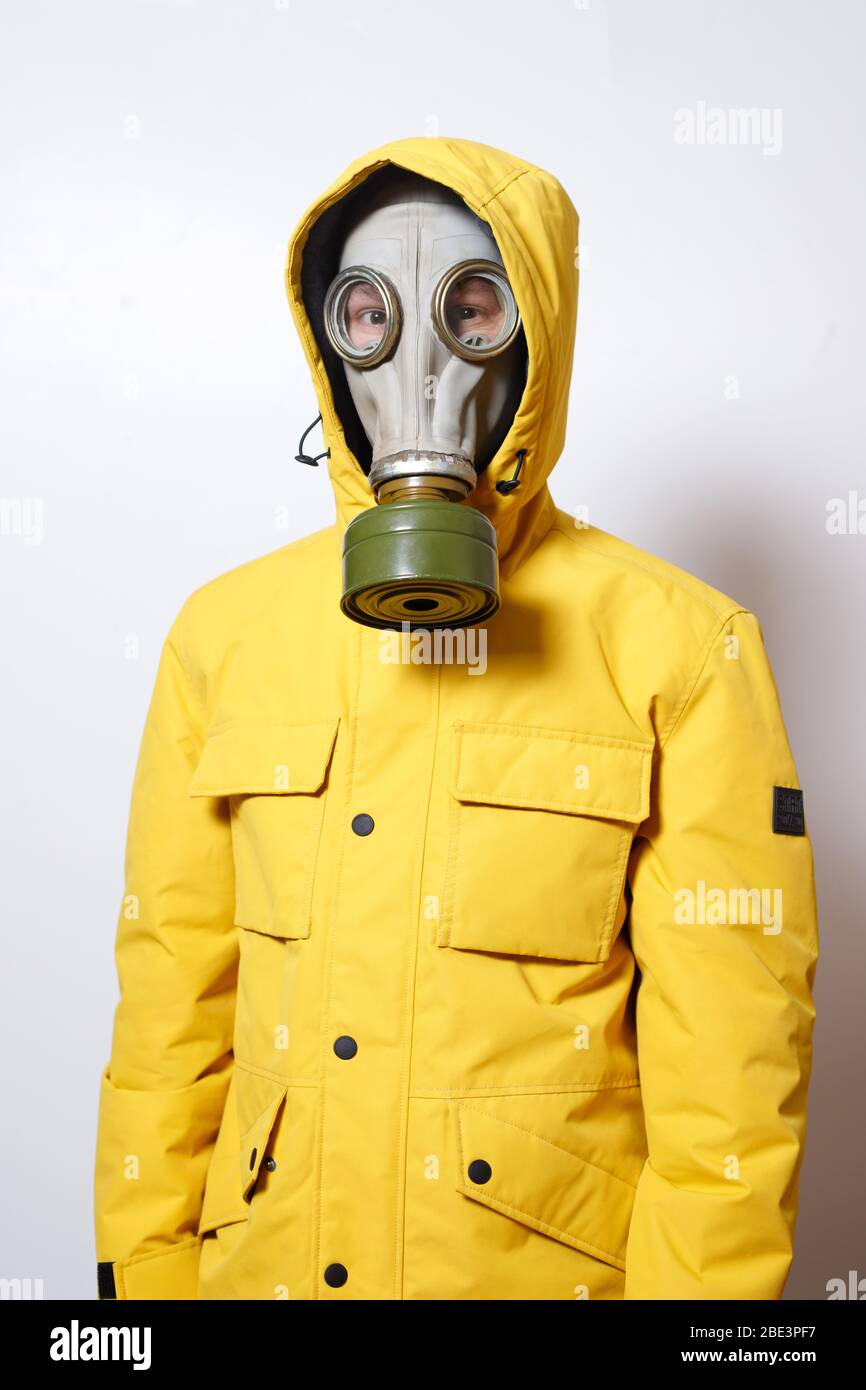 a man wears a gas mask in a yellow jacket on a white background Stock Photo  - Alamy