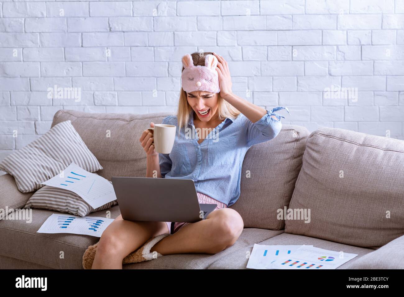 Problems in remote work. Woman screams and holds head Stock Photo