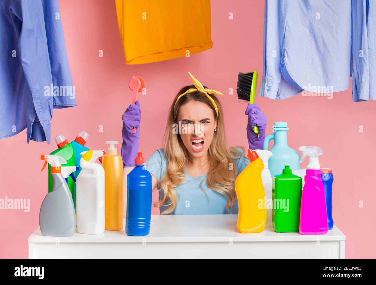 Housewife screams and holds brushes in hands Stock Photo