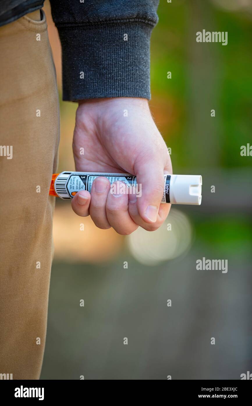 Health Medicine Epi Pen EpiPen Epinephrine Auto Injector injection needle in a mans thigh for severe allergic reaction Stock Photo