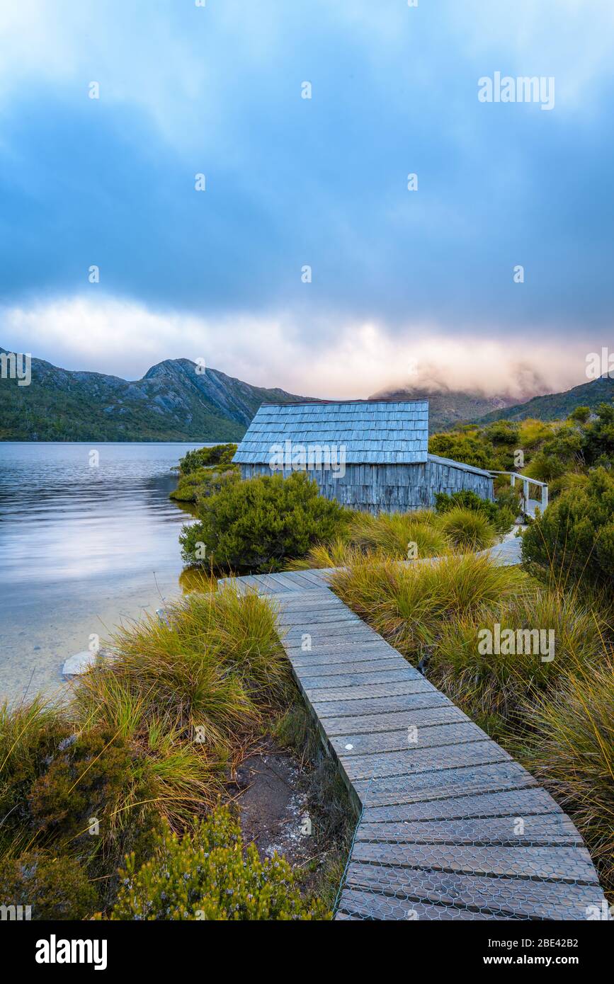 Iconic view along the boardwalk leading to the wooden boathouse on Dove Lake, in the Cradle Mountain National Park in Tasmania, Australia. Stock Photo