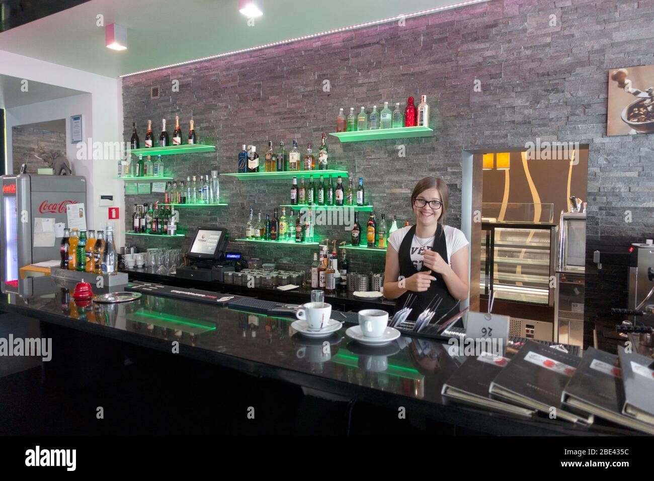 Young woman bartender at Caffe Adriano making coffees and drinks. Rawa Mazowiecka Central Poland Stock Photo