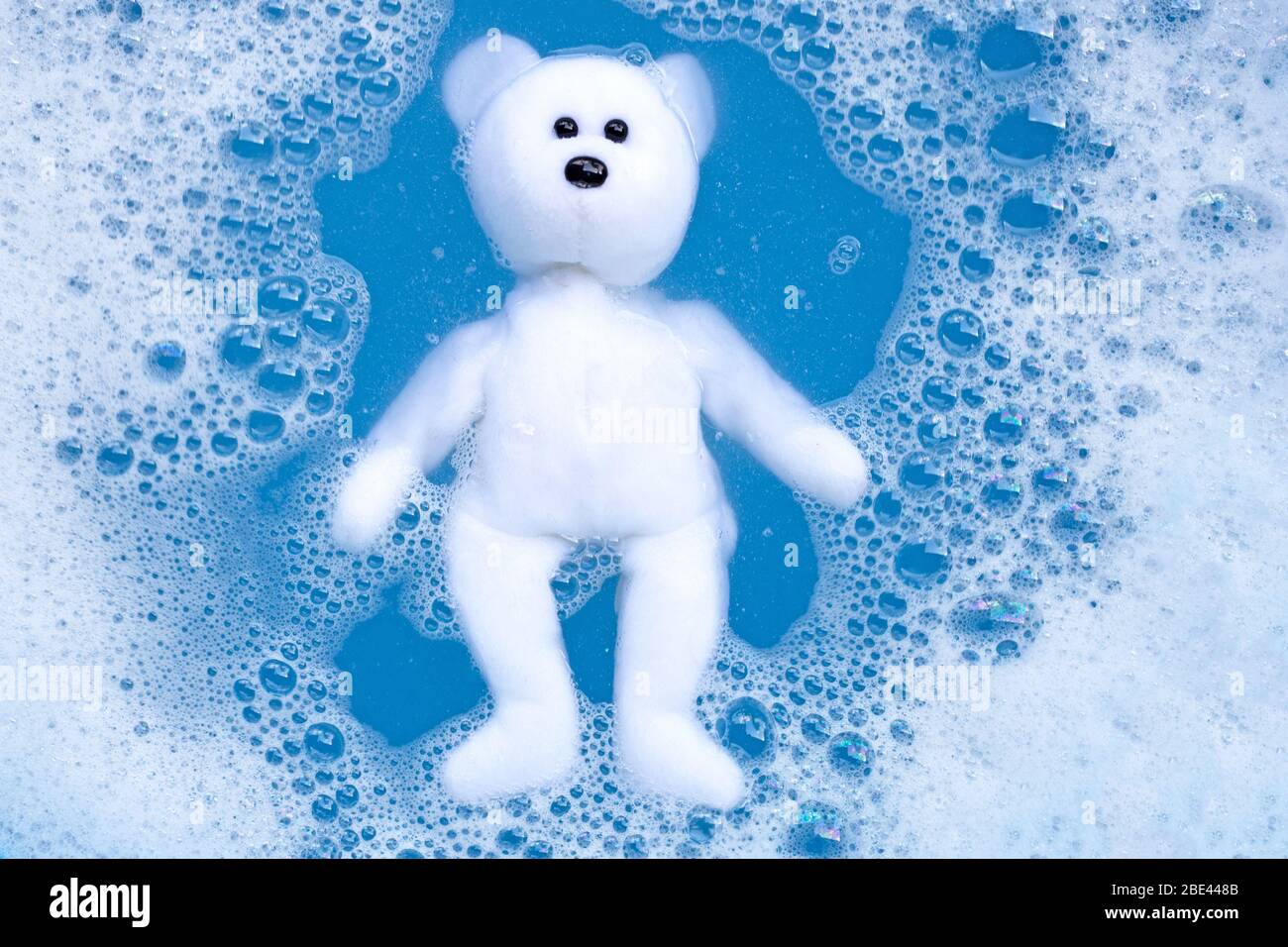 Soaking bear toy in laundry detergent water dissolution before washing