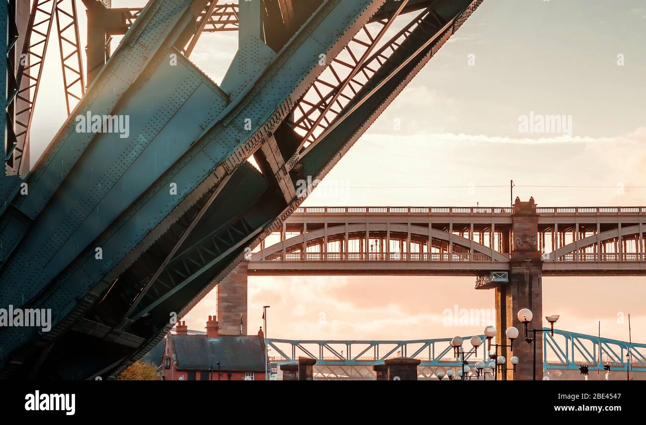 Iconic High Level Bridge and Tyne Bridge under Vibrant Sunset from the River in Newcastle upon Tyne, UK Stock Photo