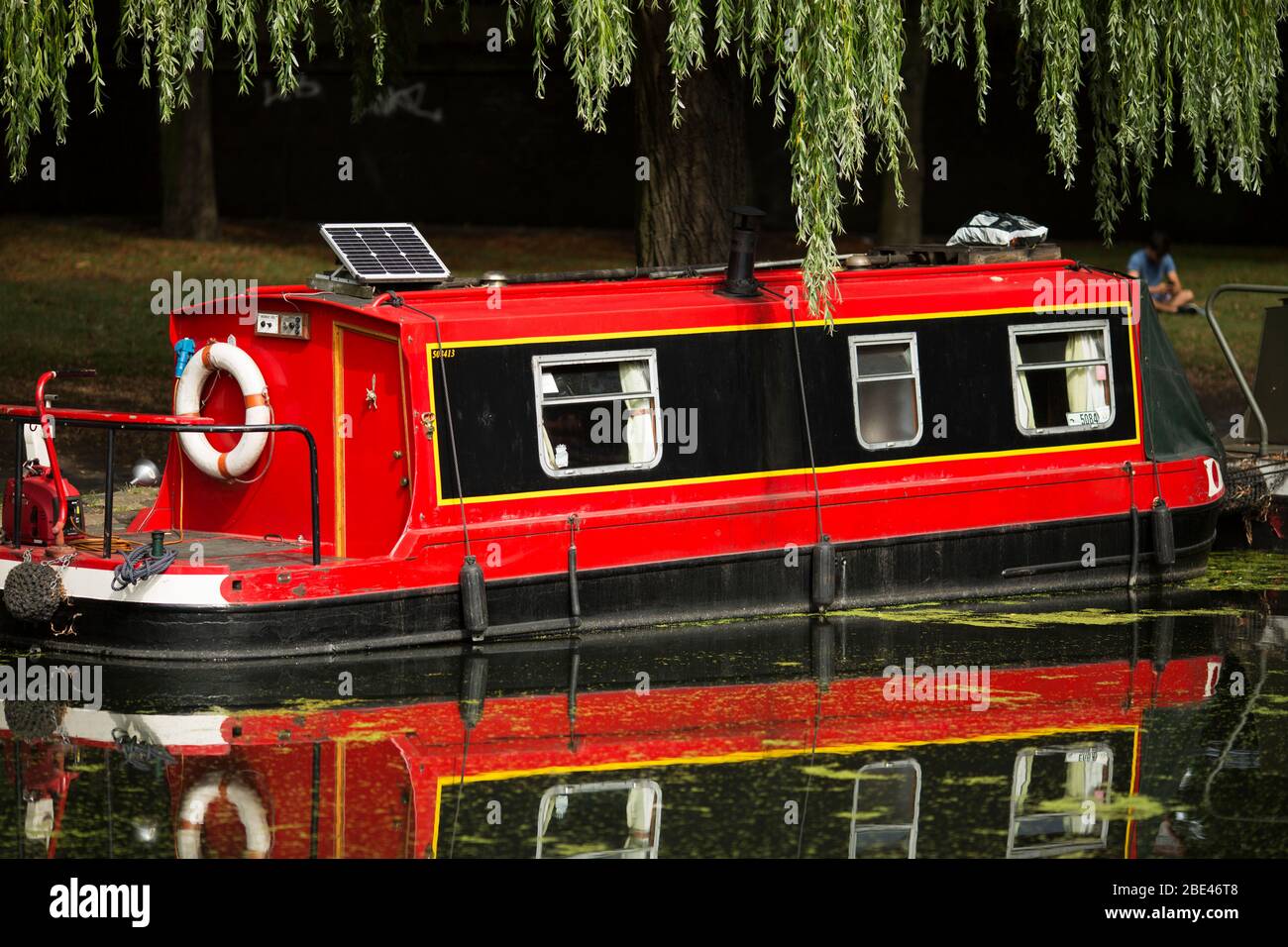 A house boat with solar panel moored on the canal in the neighborhood