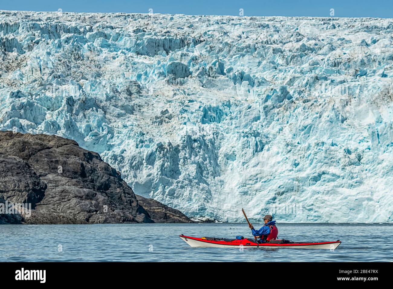 Kayaker in front of a tidewater glacier in Prince William Sound; Alaska, United States of America Stock Photo