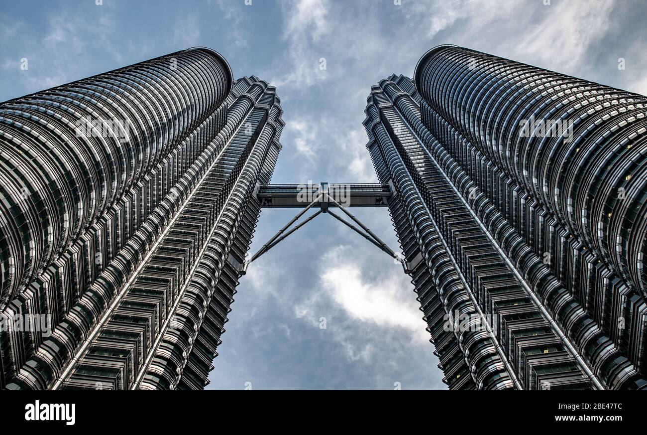 symmetrical view from below of the Petronas Towers in Kuala Lumpur - Vista simétrica desde abajo de las torres Petronas Stock Photo