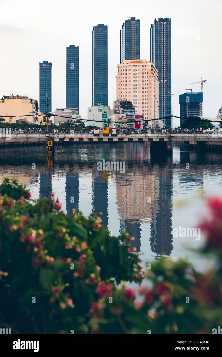 Skyscrapers in a row form the skyline and reflect in the water of the Saigon River; Ho Chi Minh City, Vietnam Stock Photo