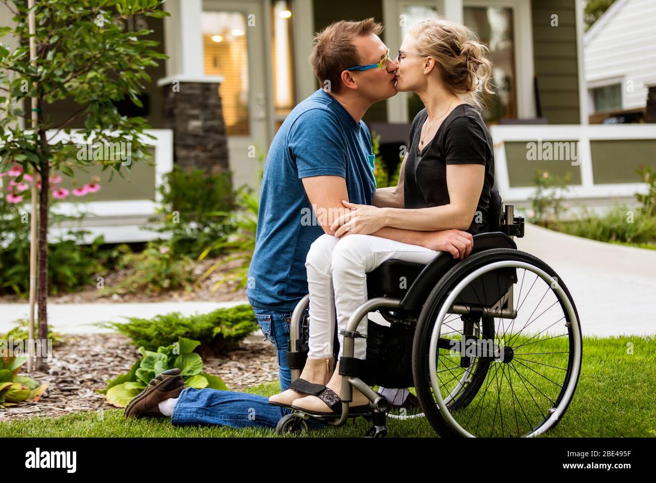 A husband and his paraplegic wife kissing in their front yard on a warm  fall day: Edmonton, Alberta, Canada Stock Photo - Alamy