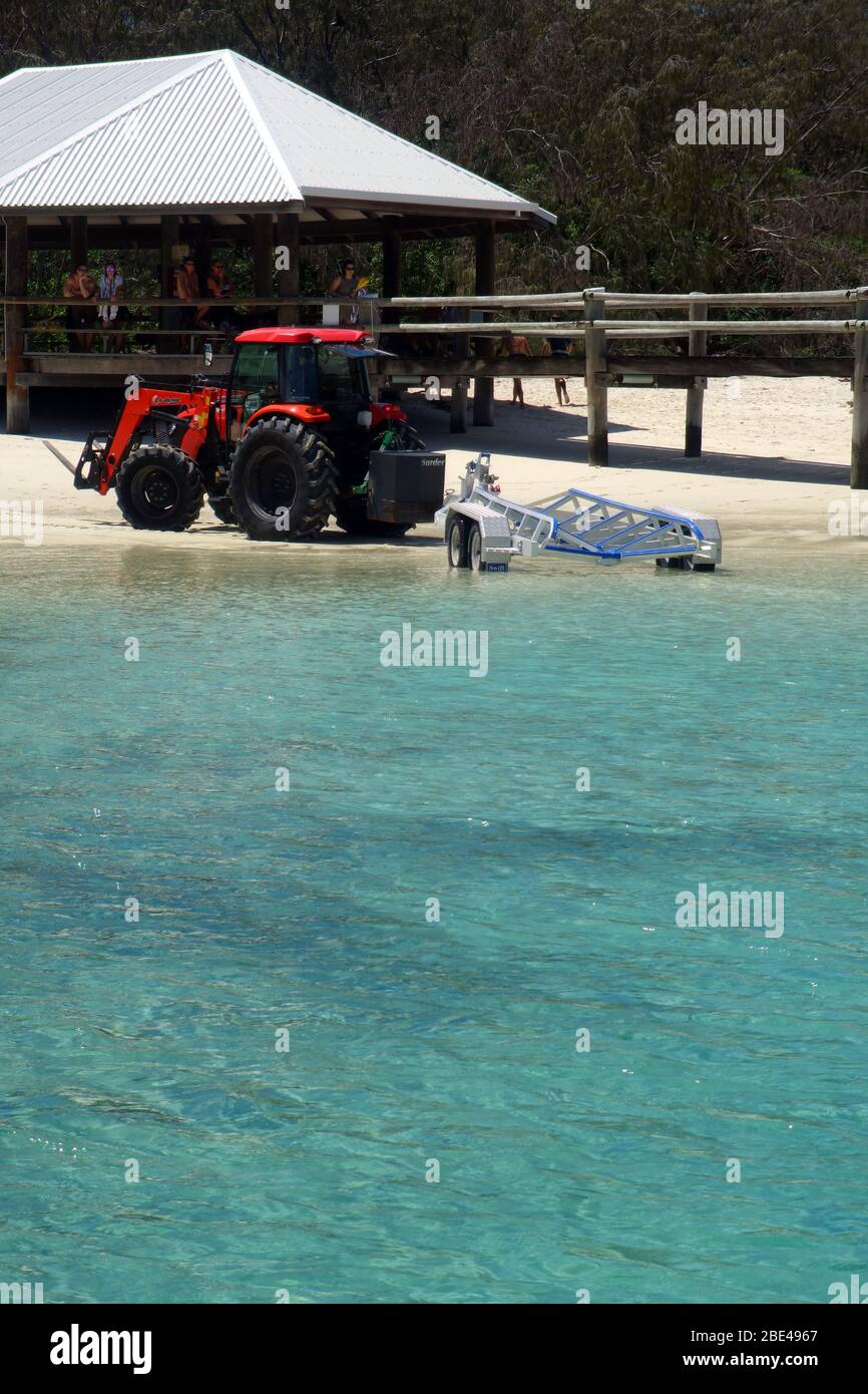 Beach tractor reversing boat trailer for research vessel while punters look on, Heron Island Research Station, southern Great Barrier Reef, Queensland Stock Photo