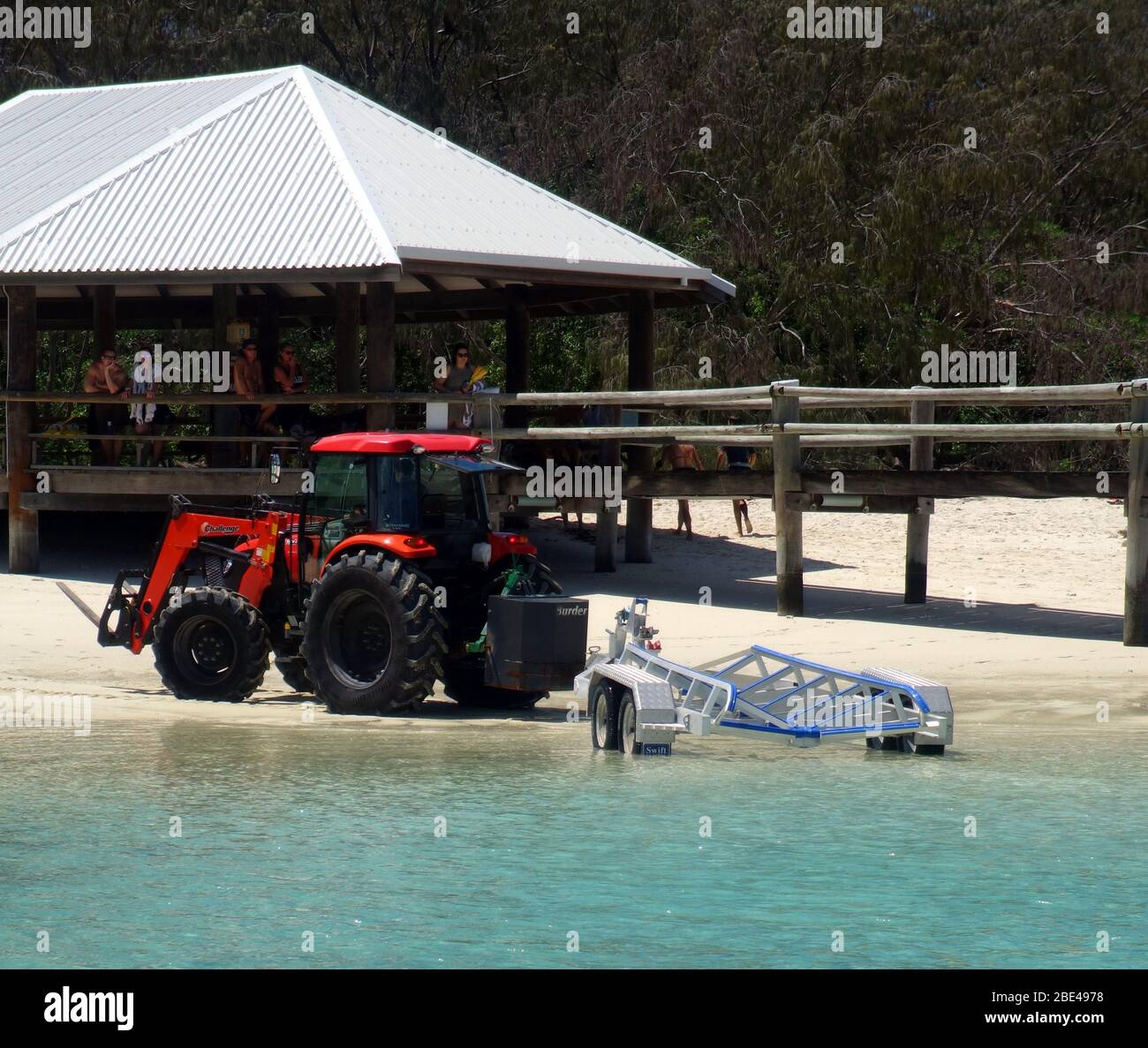 Beach tractor reversing boat trailer for research vessel while punters look on, Heron Island Research Station, southern Great Barrier Reef, Queensland Stock Photo