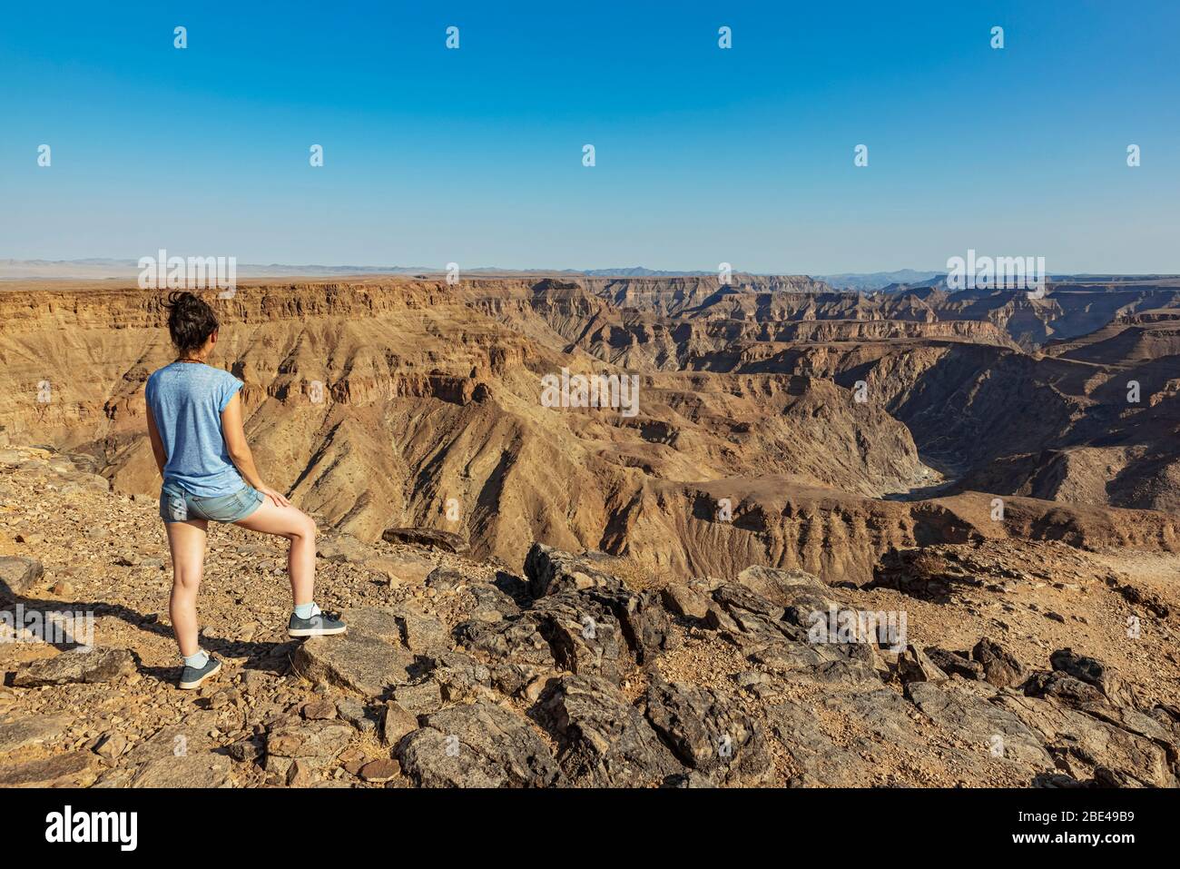 Female tourist standing and looking out over Fish River Canyon; Namibia Stock Photo