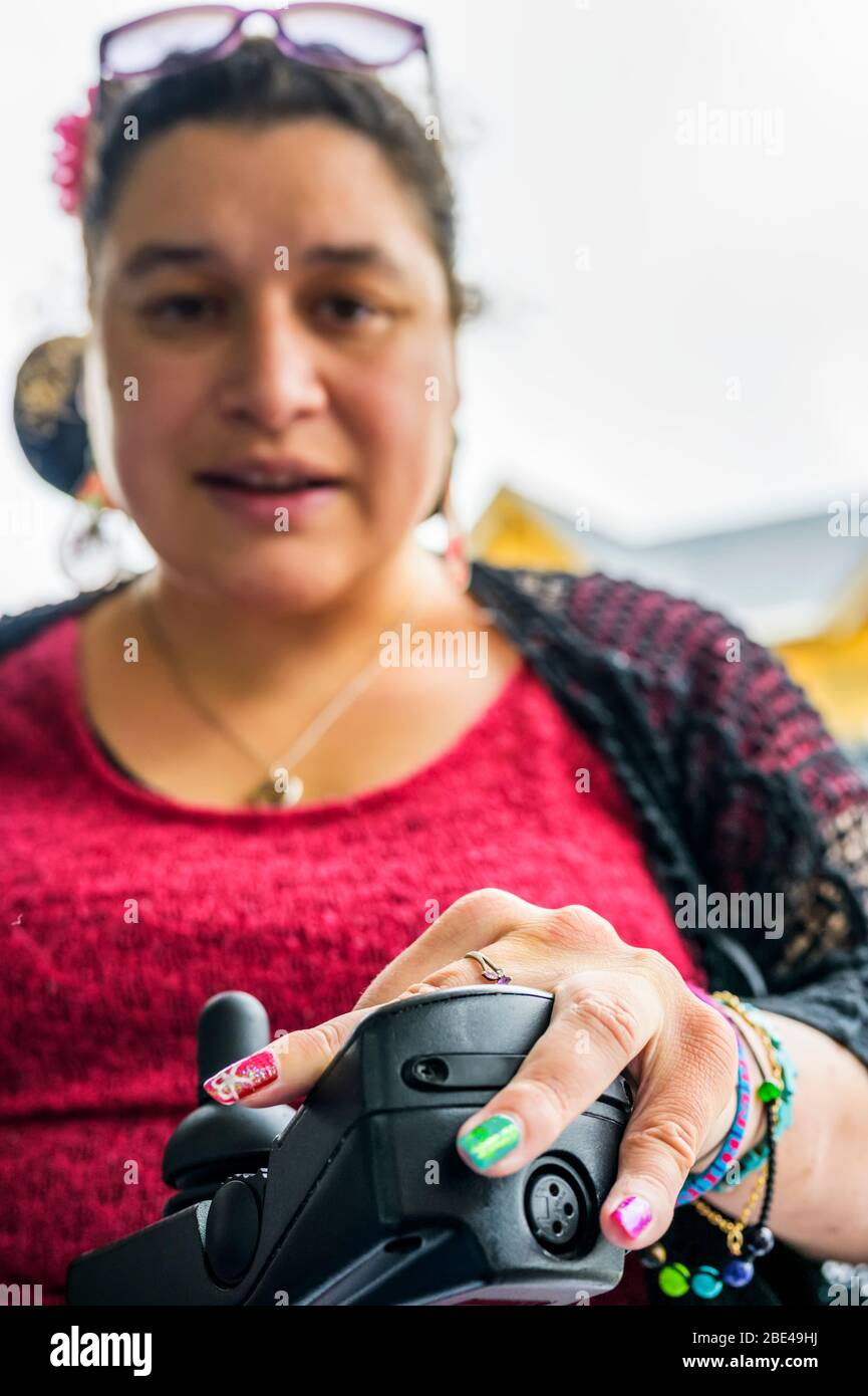 Maori woman with Cerebral Palsy in a wheelchair, fingernails showing nail art; Wellington, New Zealand Stock Photo