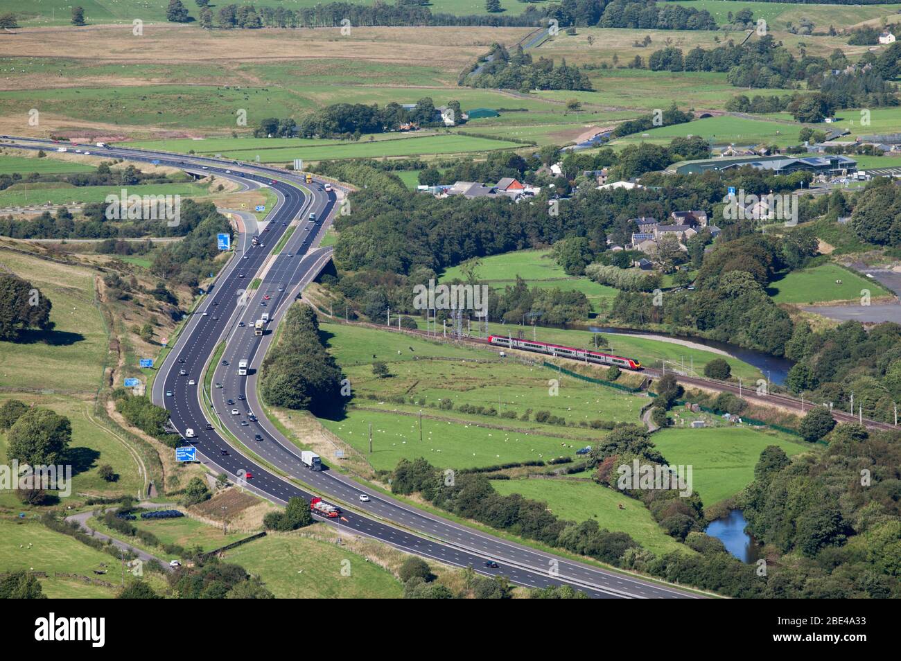 Virgin Trains class 221 voyager train on the west coast mainline running through the countryside by the M6 motorway at Tebay, Cumbria Stock Photo