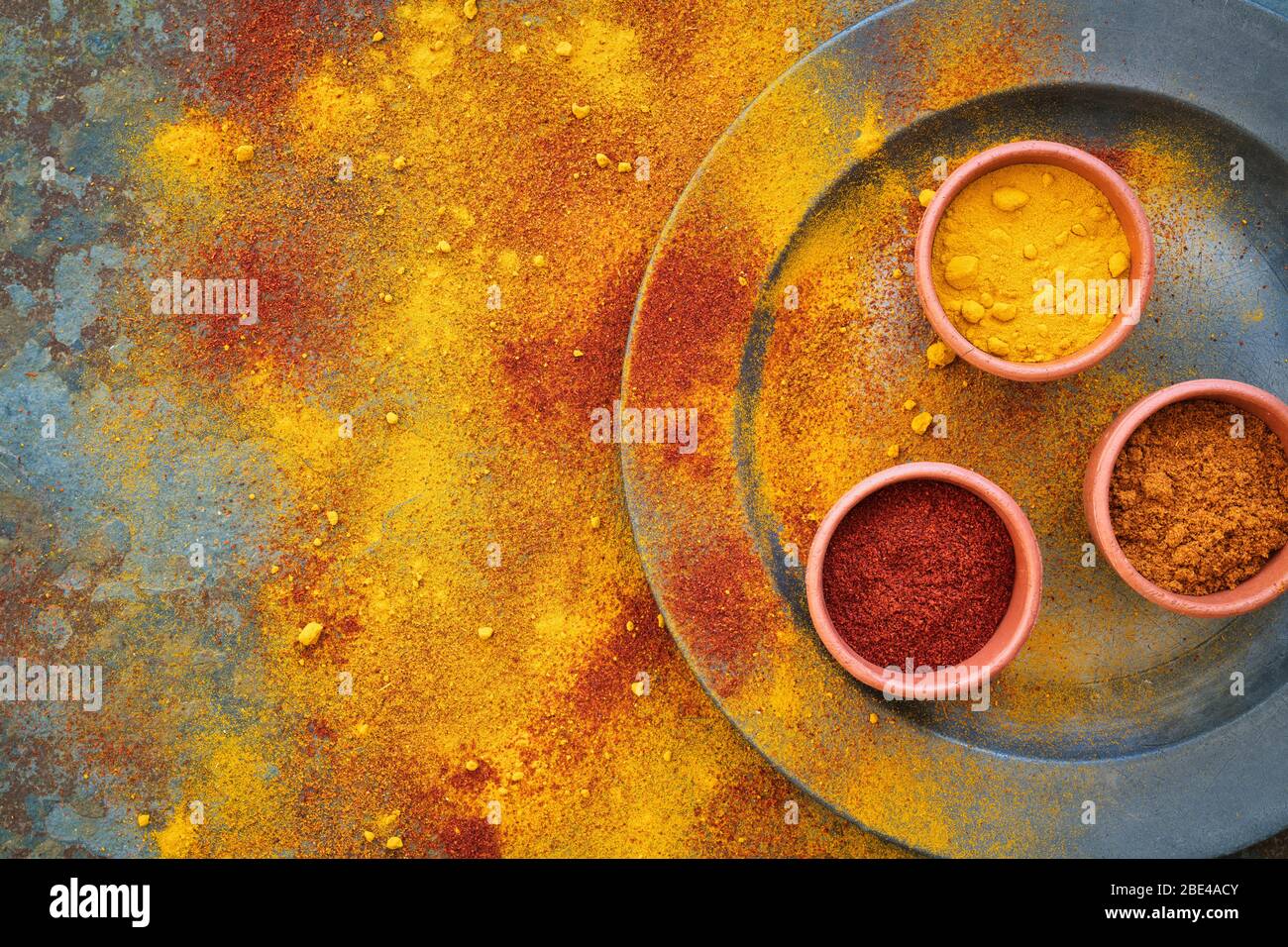 Aromatic spices on and around a pewter plate on slate background Stock Photo