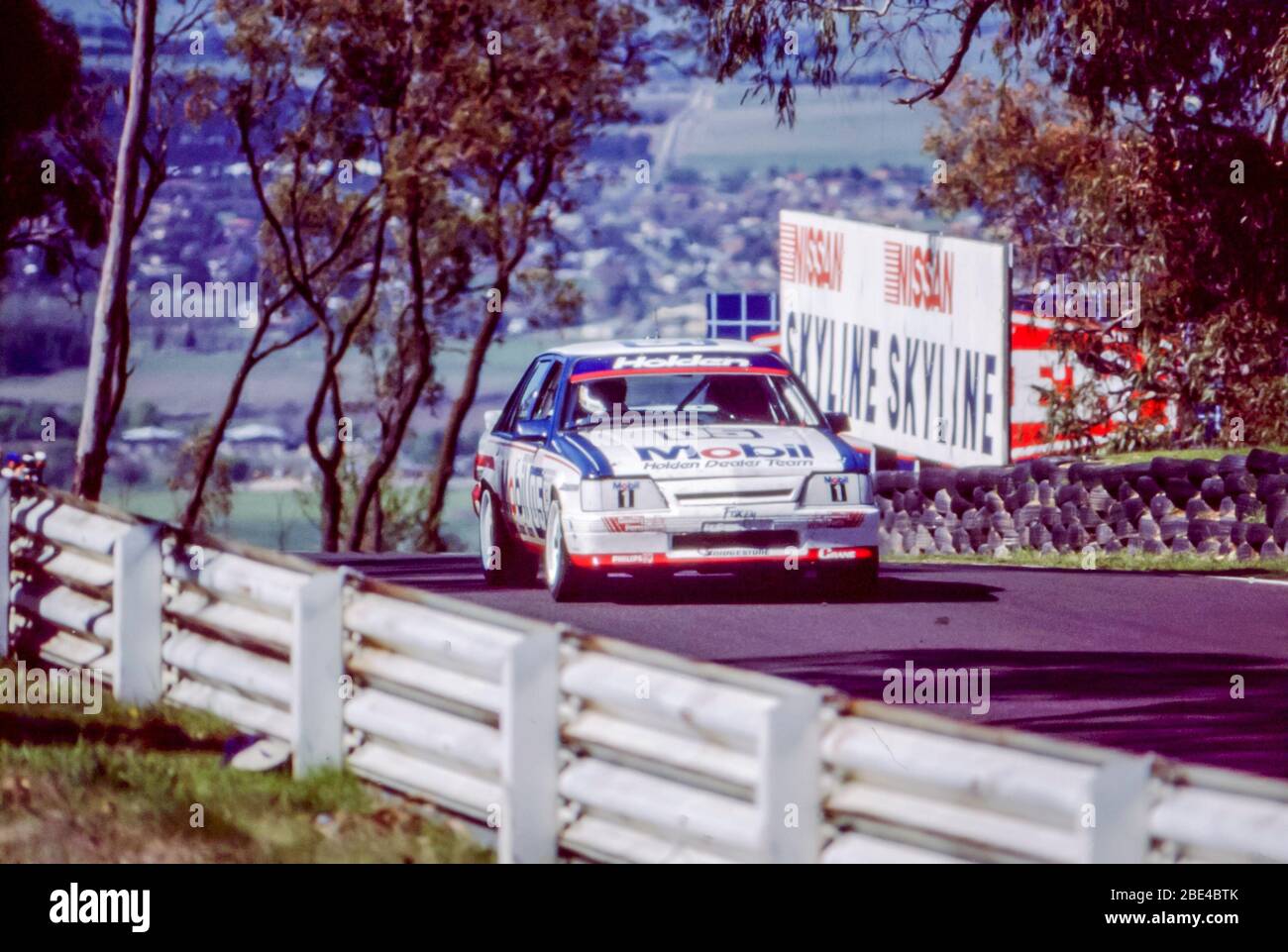 Bathurst, Australia, October 5th, 1986: Legendary Australian motor racing driver Allan Moffat teamed up with Peter Brock in his 05 Mobil Commodore. Seen here racing on an uphill section of the 1986 James Hardie (Bathurst) 1000 race. They finished in an admirable 5th place after losing a three lap advantage during pit repairs on the 1000km race. Brock and Moffat between them, had won 12 of the 16 previous races at the Bathurst circuit in Australia. Stock Photo