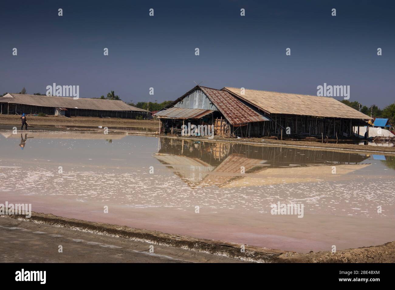 Salt is produced by the evaporation of seawater; then harvested by the salt farmers and stored in traditional buildings at Pak Thale. Stock Photo