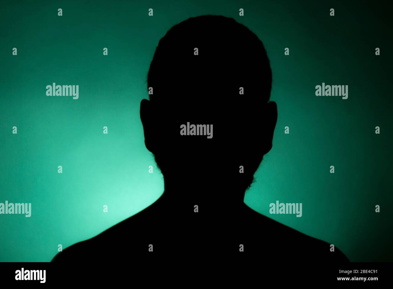 Cleanly defined frontal silhouette of a male person against a green  background with a spotlight and bright area right behind the bust. Studio  shot Stock Photo - Alamy