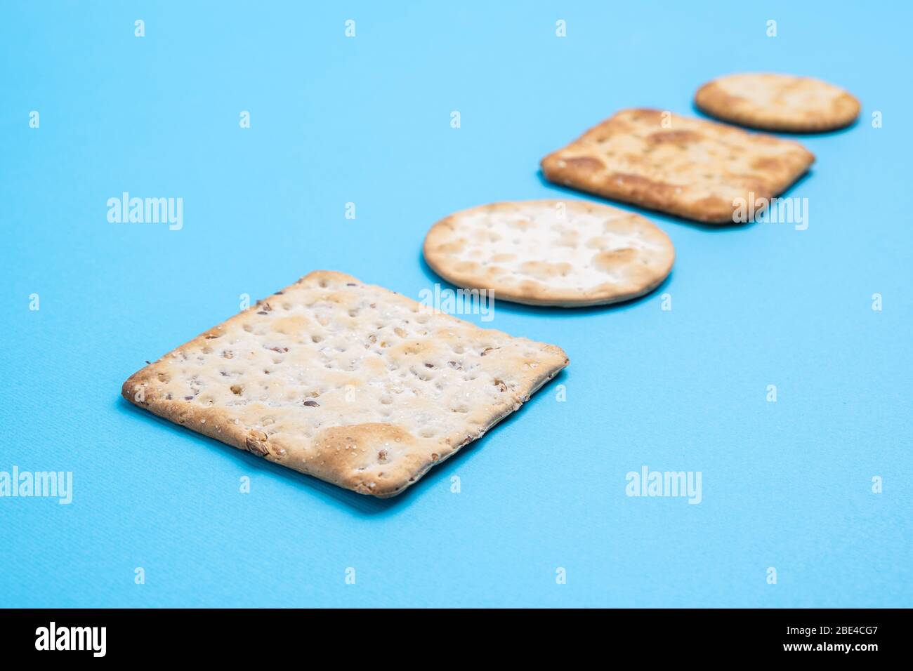 Crackers on blue background in perspective with shallow focus Stock Photo
