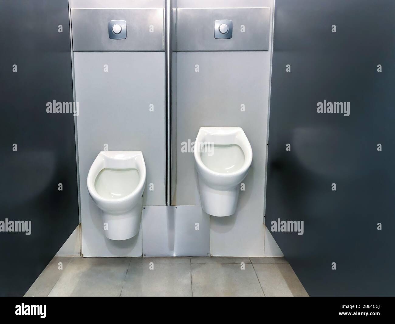 Two urinals - for adult and child in public toilet Stock Photo