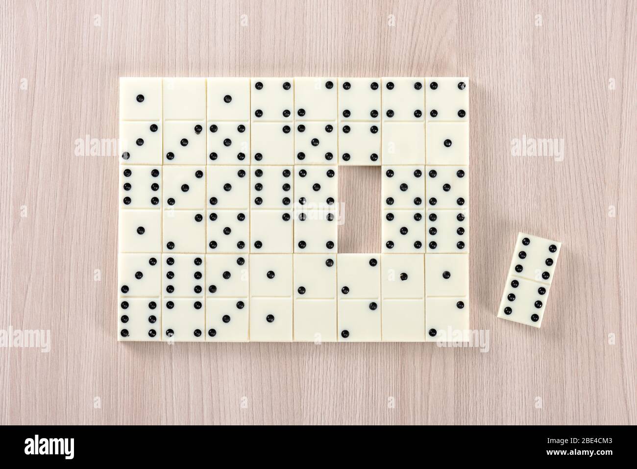 Playing dominoes on a wooden table Stock Photo