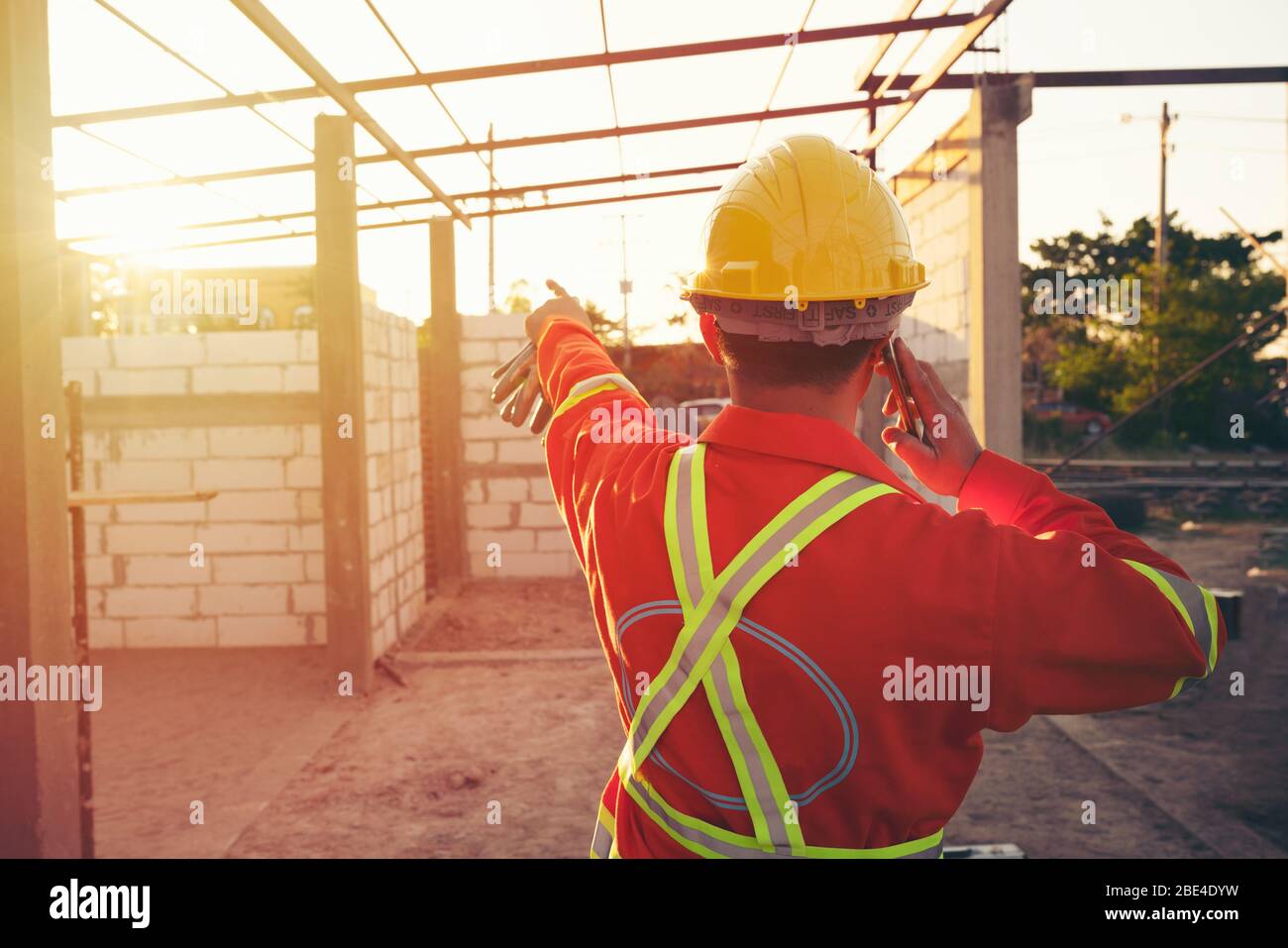 Engineer wear a hard hellmet and using smartphone  at construction site Stock Photo