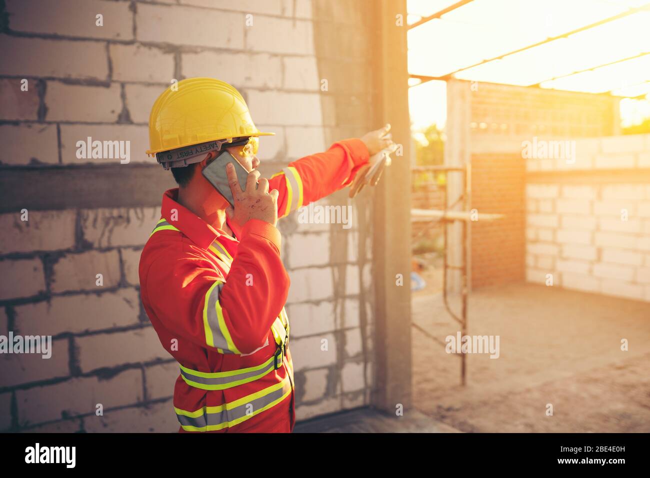 Engineer wear a hard hellmet and using smartphone  at construction site Stock Photo