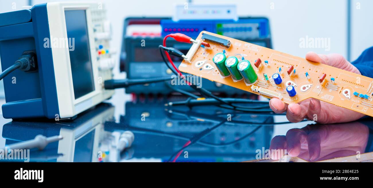 Debugging electronics device. PCB witch microcontroller in electronics laboratory Stock Photo