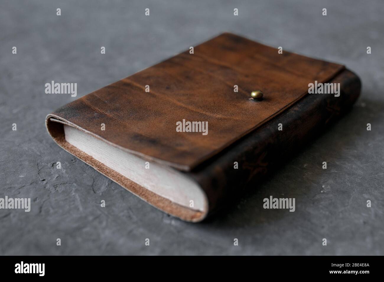 open craft notepad with leather cover l on gray background. Stock Photo