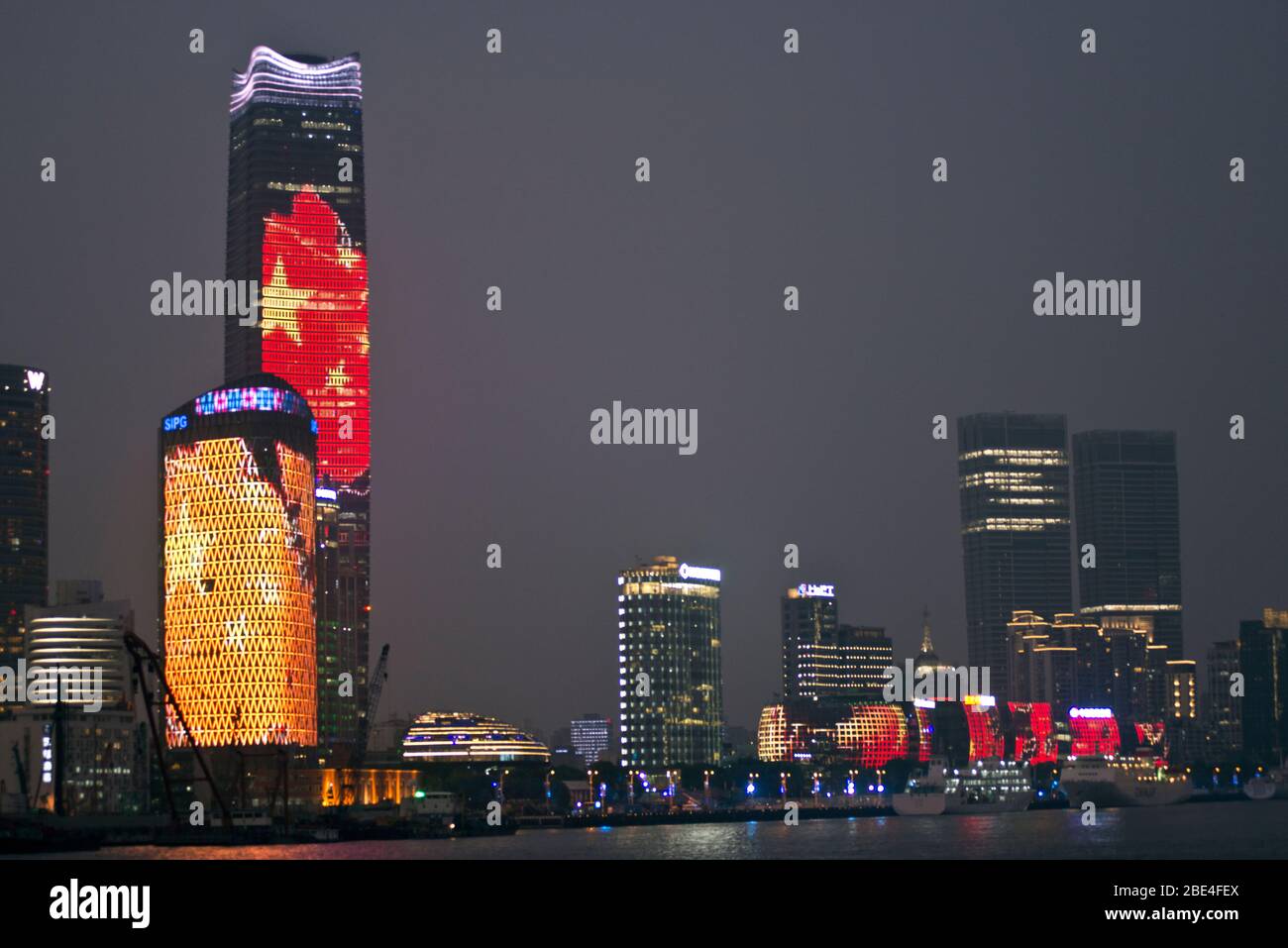 Shanghai skyscrapers at night picturing the Chinese flag, illuminated by LED lighting, view from the Bund, China Stock Photo