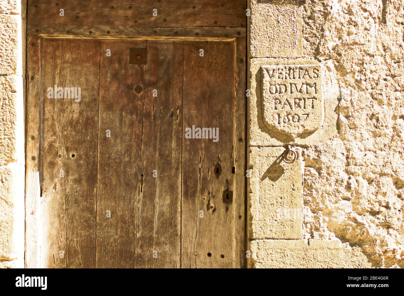 17th century inscription next to a wooden door in the medieval town of Mirepoix in southern France Stock Photo
